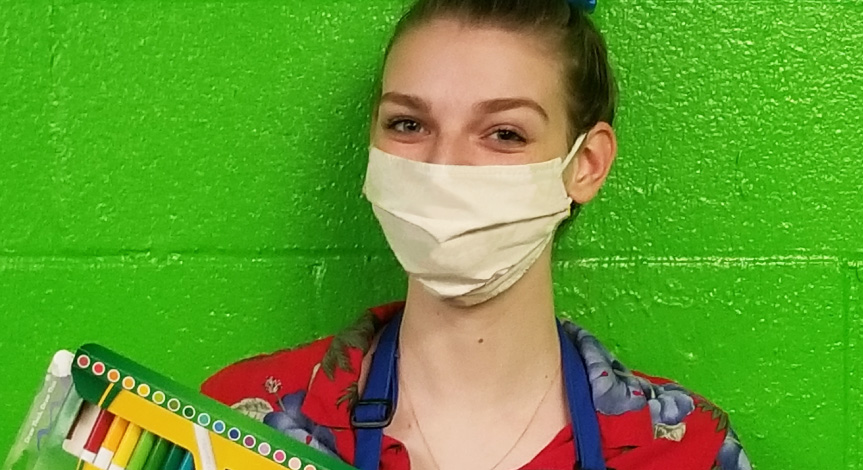 Crayola Imagine Arts Academy art instructor wearing a mask following safety guidelines while holding crayola markers 