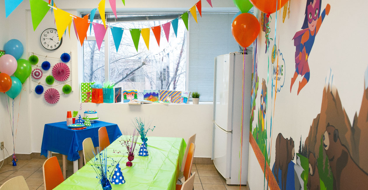 A Crayola Imagine Arts Academy art studio setup for an art birthday with balloons party hats and streams